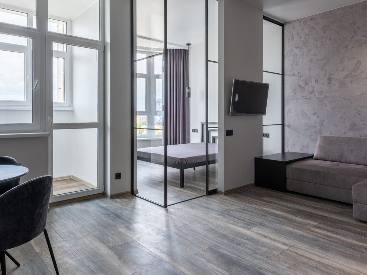 Modern apartment with wide grey-toned engineered plank flooring running through the living area